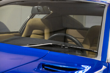 Windscreen and steering wheel of blue vintage car