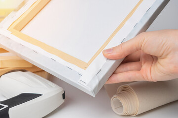 The process of stretching a canvas with a photo on a stretcher in the framework shop.The back of...