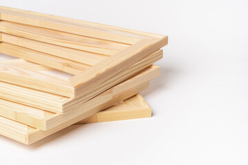 A stack of wooden stretchers on a white background, copy space