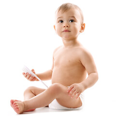 Little boy in diaper sitting and playing with brush.