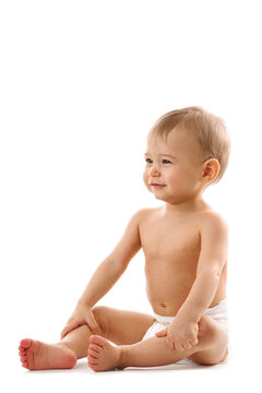 Curious healthy little boy in diaper sitting and smiling.