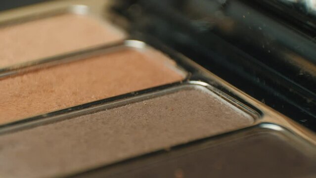 This close-up video showcases a rotating professional makeup eyeshadow palette of browns.