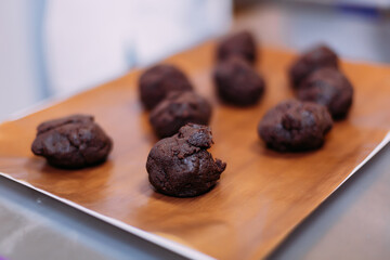 Blanks for potato cake. Chocolate sponge cake on a wooden cutting board. Chocolate brownie potatoes on the table