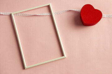 White frame on pink background and red heart
