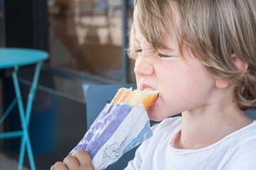 Close up of boy biting wrapped food