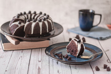Dark chokolate bundt cake topped with white chokolate glaze and black currant