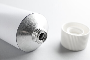 Open ointment tube on white background, closeup