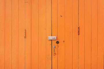 Old orange wooden doors closed in outdoor.