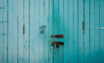 Old blue wooden doors closed in outdoor.