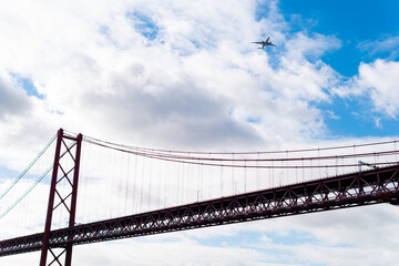 Fototapeta na wymiar April 25 bridge from below as an airplane passes overhead in Lisbon