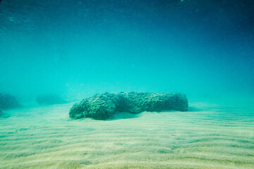 Underwater scene with rocks on sand
