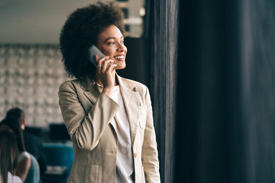 Beautiful african corporate worker talking on mobile phone