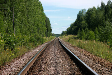 The railway track goes into the distance on a sunny summer day.