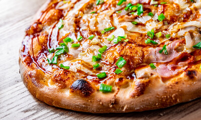 Pizza with chicken and barbeque sauce. Italian pizza on wooden table background