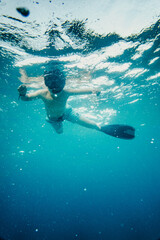Boy with swimming mask and flippers snorkeling in sea