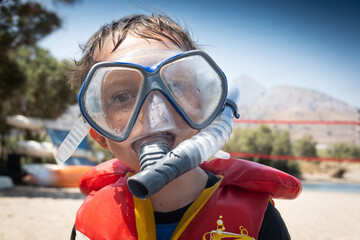 Close-up of boy with diving mask and life jacket