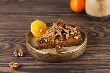 Homemade cake with walnuts and tangerines on a wooden table. Healthy food, sugar, gluten and lactose free, vegan.