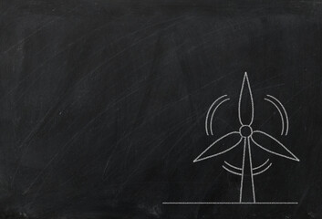Rotating windmill symbol chalk drawing on blackboard. Alternative renewable energy source.