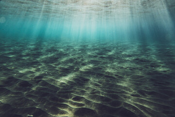 Underwater scene with sunlight on rippled sand