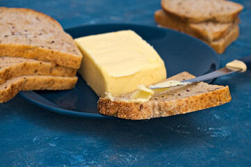 butter and toast bread on a blue plate. close. macro.