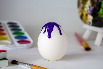 White Easter egg on a watercolor background. Simple holiday composition. Symbolism of the Easter egg festival concept. Art work, handmade, creativity with children for decoration for Easter