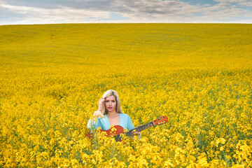 Fototapeta premium sexy woman in the field with a guitar. concept freedom, inspiration, relaxation