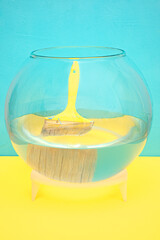 yellow construction brush in an aquarium with water. blue background.