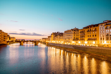 Fototapeta na wymiar Landscape of Florence old town, night view from the bridge on Arno river and riverside. Beautiful sunset cityscape of Firenze, Italy