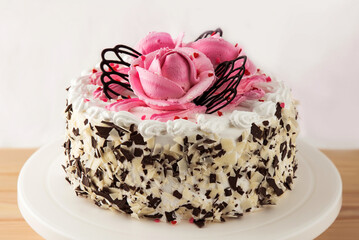 Beautiful birthday cake on the table close-up. The confection is decorated with cream roses.