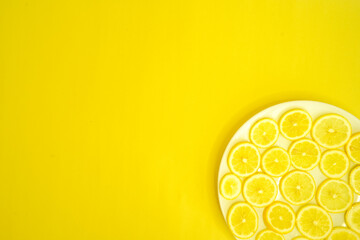 sliced lemons in a plate on a yellow background 