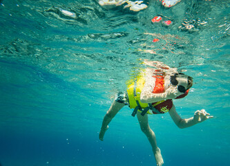 Boy wearing goggles with life jacket having fun in sea