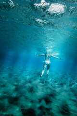 Woman swimming underwater in sea