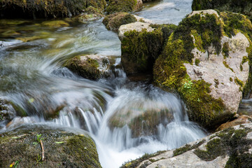 Running water along large stones with moss