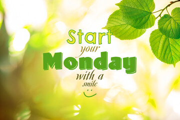 Motivational quote Start your Monday with a Smile and green leaves on blurred background. Bokeh...