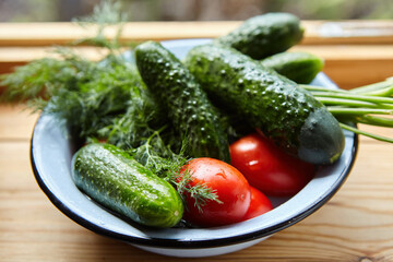 Vegetables for salad are in a bowl on a wooden table. Organic vegan food.