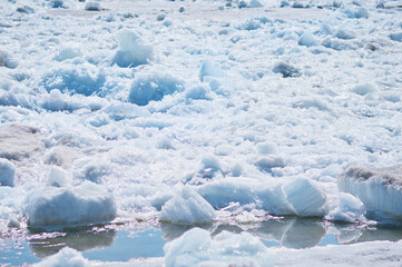 Melting ice floes in spring. A heap of blocks and fragments. Ice drift on the Amur River. Sunny day. Drifted ice pieces. © Алексей Игнатов