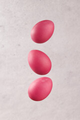 Levitating dyed eggs on a gray background. Easter celebration concept