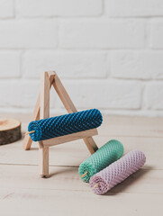 Multicolored beeswax candles with honeycomb texture on a wooden floor.
