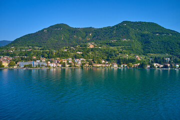 Fototapeta na wymiar Tourist site on Lake Garda. Lake in the mountains of Italy. Aerial view of the town on Lake Garda. Panoramic view of the historic part of Salò on Lake Garda Italy.