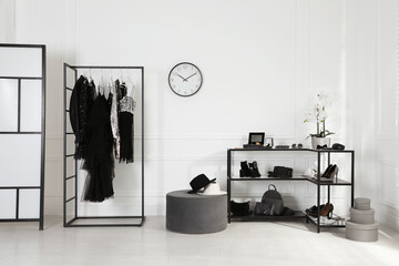 Stylish dressing room interior with trendy clothes, shoes and accessories