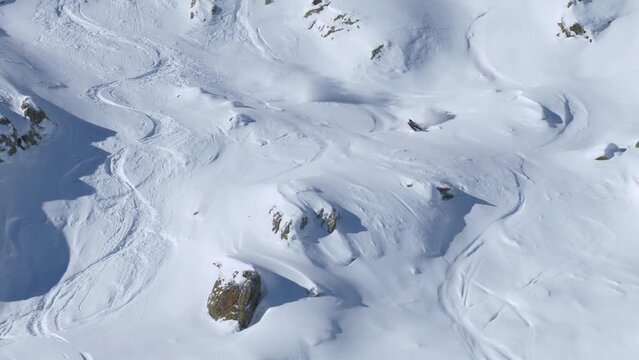 Skier riding down rocky, natural powder snow slopes and crashing - handheld view