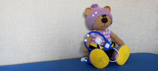 Teddy bear and stethoscope on gray background, copy space, concept run Pediatric, children's...