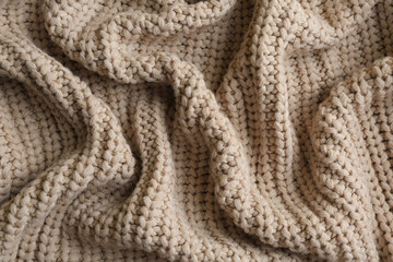 Beautiful beige knitted fabric as background, top view