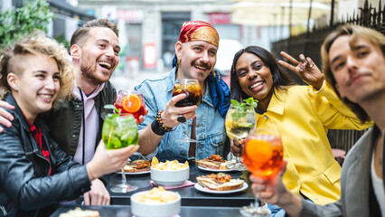 Lgbt group of diverse people sitting at bar, happy friends taking a selfie at the restaurant drinking cocktails, social media and inclusion concept