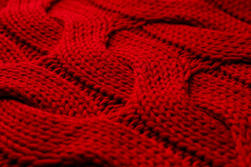 Beautiful red knitted fabric as background, closeup