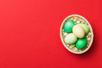 Multi colors Easter eggs in the woven basket on colored background . Pastel color Easter eggs. holiday concept with copy space