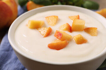 Delicious yogurt with fresh peach in bowl, closeup