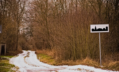 Znak drogowy " Obszar Zabudowany " .... w środku lasu . Leśna droga do Czarnej Gliny , śródleśnej miejscowości , zimą posypana śniegiem .