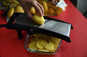 Couper des pommes de terre avec une mandoline de cuisine