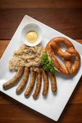 traditional german bavarian meal of sausages with sauerkraut and pretzel